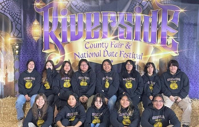 Sherman Indian FFA team posing while sitting on hay. 