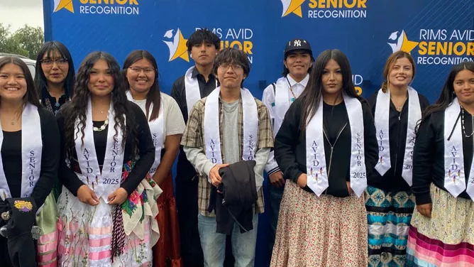 Ten high schoolers stand for a group photo in front of a blue backdrop that says RIMS AVID Senior Recognition.