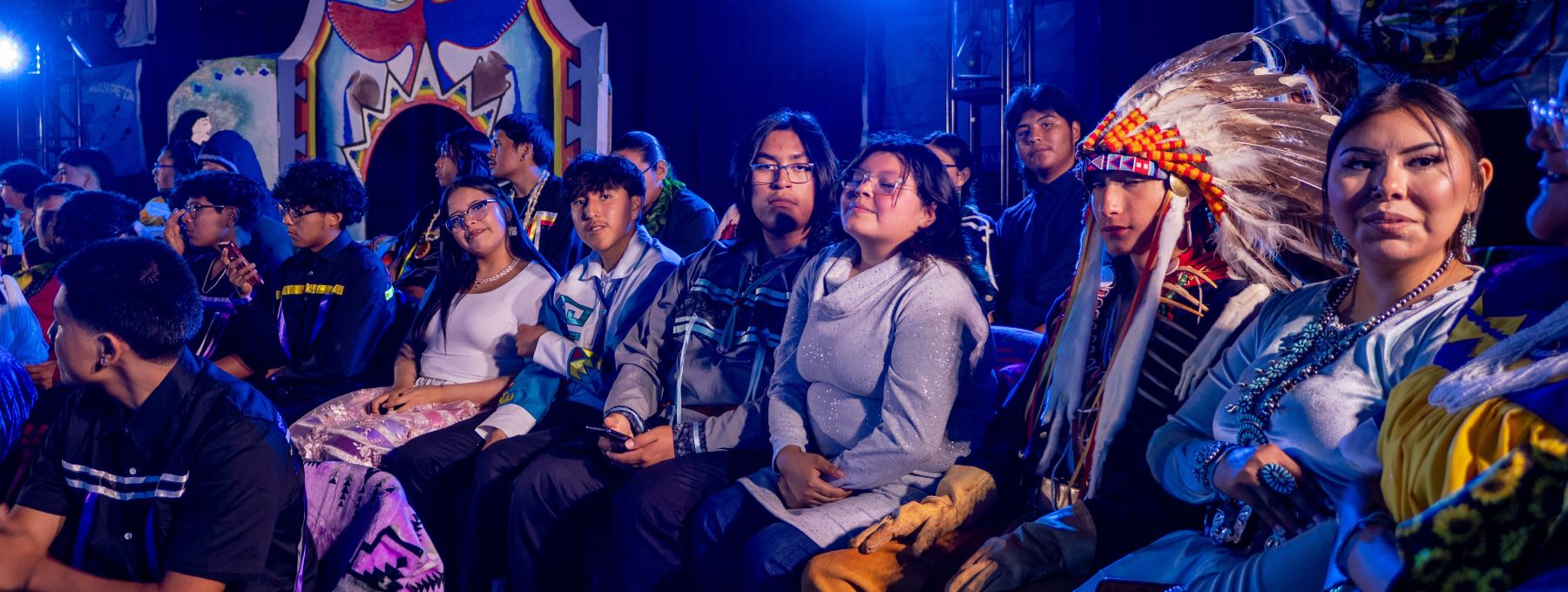 Several students sitting together, during a live event at the school.