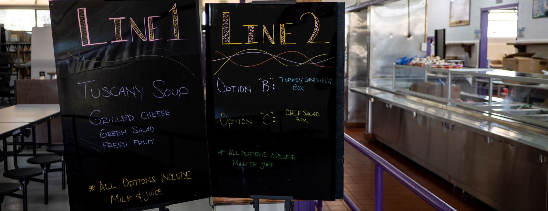 School cafeteria signs indicating "Line 1" and "Line 2", guiding students to the correct queue.