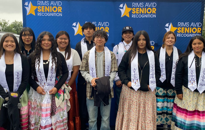 Ten high schoolers stand for a group photo in front of a blue backdrop that says RIMS AVID Senior Recognition.