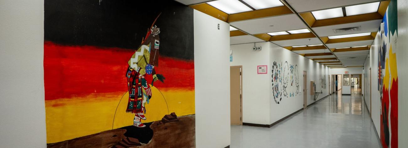 A hallway adorned with a mural depicting a Native American man, highlighting cultural heritage through artistic expression.